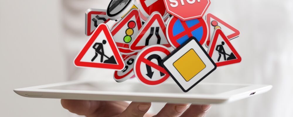 Eine Hand mit einem Tablett voller Verkehrszeichen